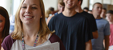 Students smiling at a screen.