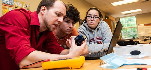 Two students working with a faculty member