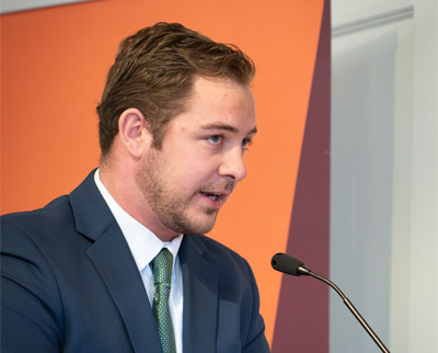 Bailey Blaschak speaks at a podium.