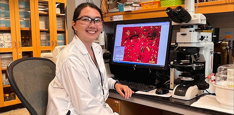 Christina Vo '25 sits at a computer in a lab