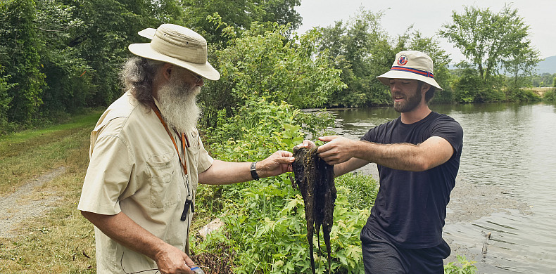 Jack Holt, professor of biology, left, and Michael Rose '25, right, collect algae samples from a local lake.