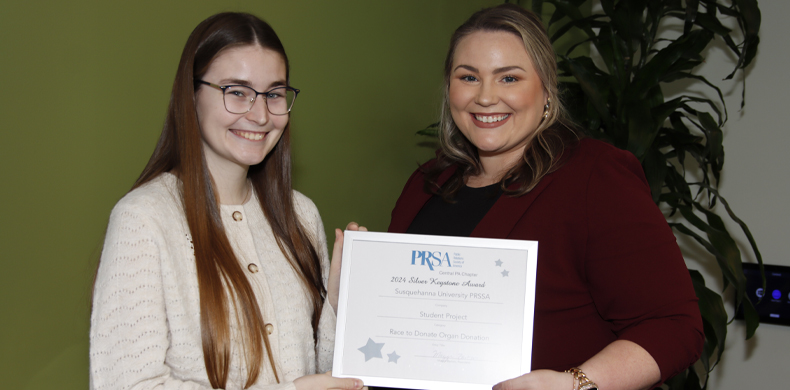 Avery Atkins '25 accepts a Silver Keystone Award from Maggi Barton, former president of PRSA Central PA, president-elect of Mid-Atlantic.